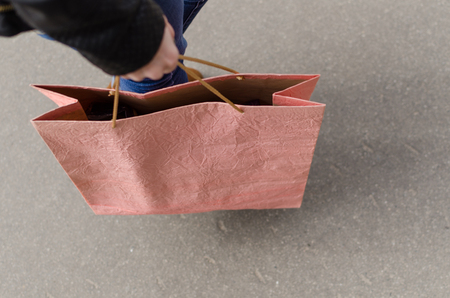 Young blonde woman walking on the street with shopping bagsの写真素材