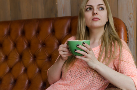 Young woman drinking cofee from the cup in the cityの写真素材