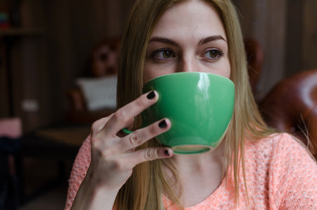 Young woman drinking cofee from the cup in the cityの写真素材