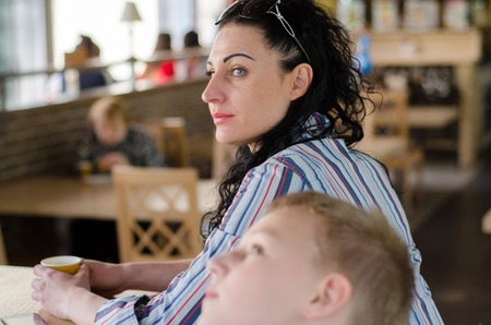 girl drinking cofee in the cafe with her sonの写真素材