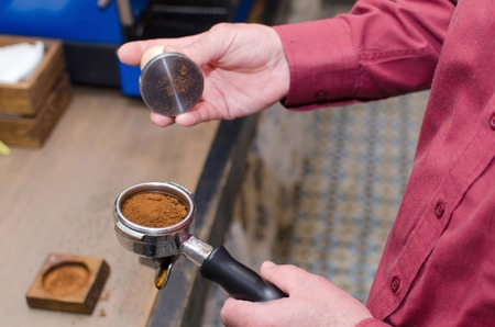 Aged man making coffee with coffee machineの写真素材