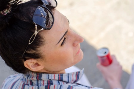 young girl sitting on the steps and resting in the shadowの写真素材