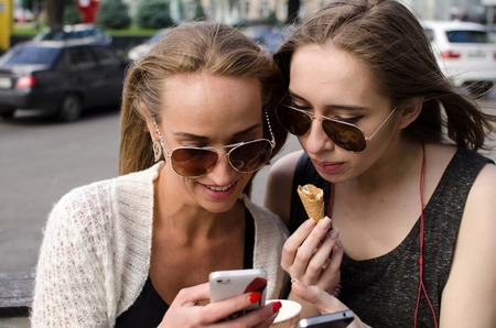 Two girlfriends are making selfie on the streetの写真素材