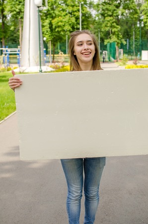 Young girl with the white banner in the cityの写真素材