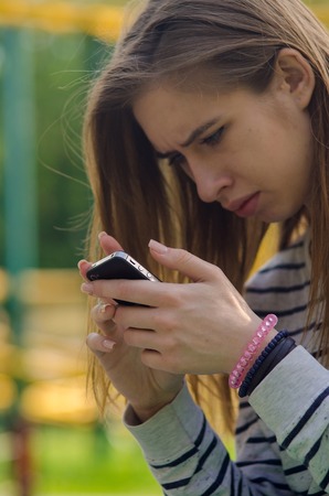 Young woman using her phone on the streetの写真素材