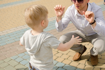 Small baby boy is having fun in the park with his fatherの写真素材