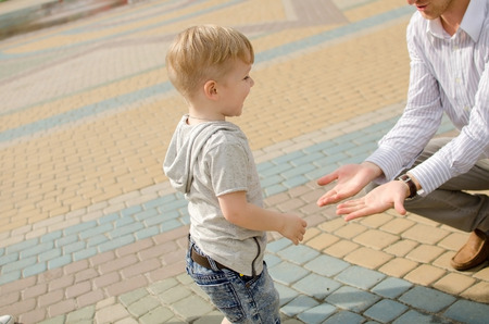 Small baby boy is having fun in the park with his fatherの写真素材