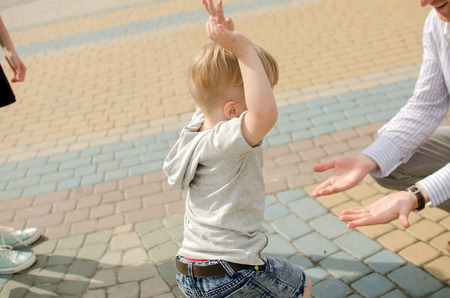 Small baby boy is having fun in the park with his father