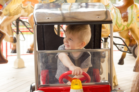 Little boy is riding the car and smilingの写真素材
