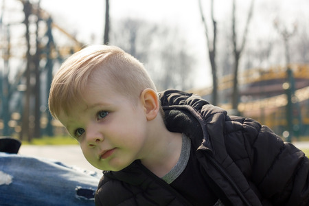 Close-up photo of little boy with blue eyes looking asideの写真素材