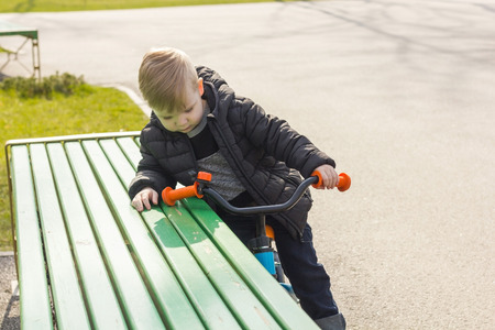 Little boy is leaning on the benchの写真素材