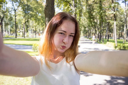 Young woman making selfie in the parkの写真素材