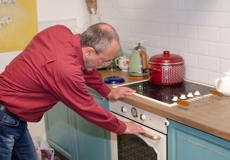 Aged man cooking on the kitchenの写真素材