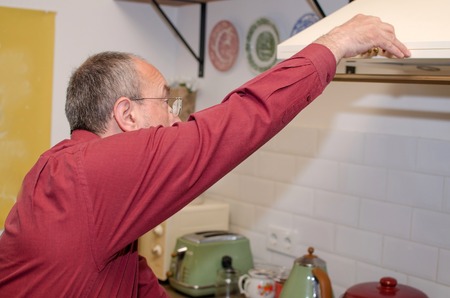 Aged man cooking on the kitchenの写真素材