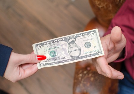 Closeup of woman passing money to manの写真素材