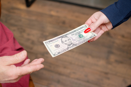 Closeup of woman passing money to manの写真素材