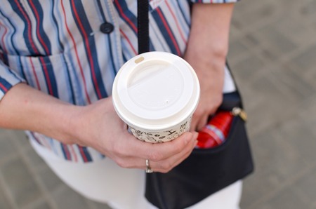Young girl walking on the city streets with cofeeの写真素材