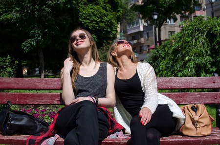 Two girlfriends are resting in the parkの写真素材