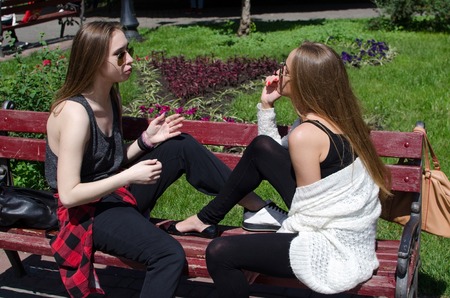 Two girlfriends are resting in the parkの写真素材