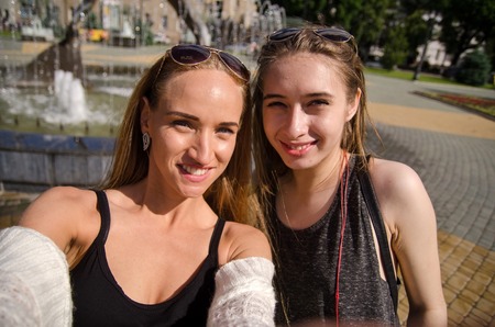 Two girlfriends are having fun walking in the cityの写真素材