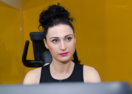 Young woman is training on the bicycle in the gymの写真素材