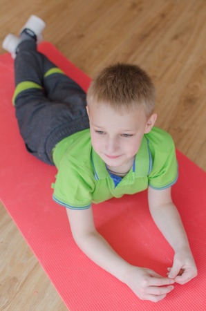 Young boy is making sports exercisesの写真素材