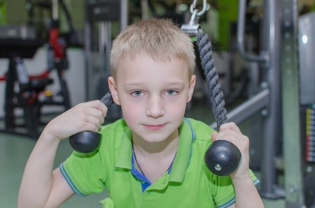 Young boy is training in the gymの写真素材