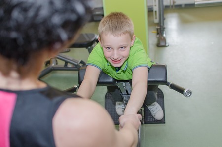 Mother helping her son in the gymの写真素材