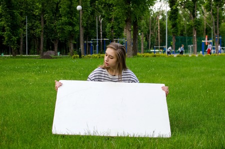 Young girl with the white banner in the cityの写真素材