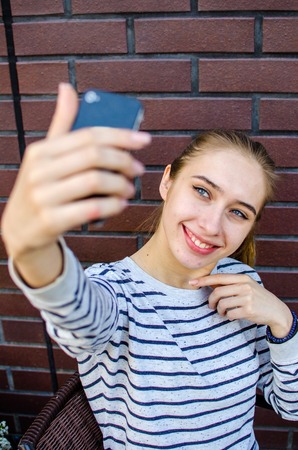 Young girl making selfie with her cell phoneの写真素材