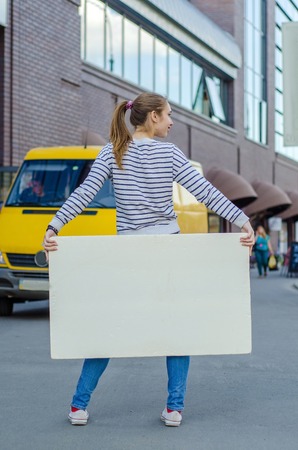 Young girl with the white banner in the cityの写真素材