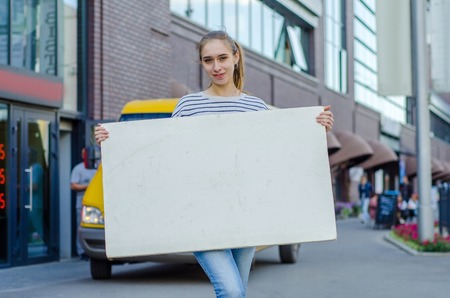 Young girl with the white banner in the cityの写真素材