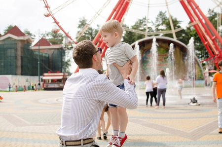 Small baby boy is having fun with his father in the parkの写真素材