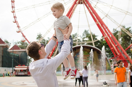 Small baby boy is having fun with his father in the parkの写真素材