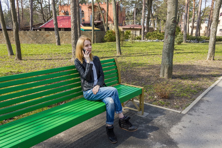 Beautiful woman is talking on the phone in the park and smilingの写真素材