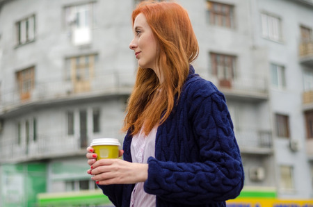 Young red woman with hot tasty coffeeの写真素材