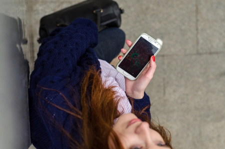 Young red woman using her cell phoneの写真素材