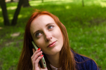 Young red woman using her cell phone