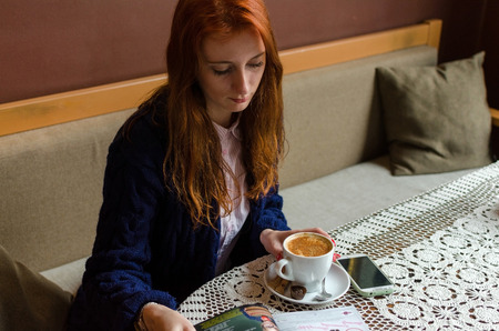 Young red woman using her cell phoneの写真素材