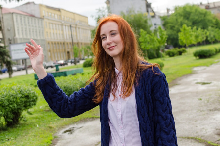 Young woman saying hi to a friend on the streetの写真素材