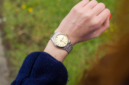 Close up of young woman looking at her hand watchの写真素材