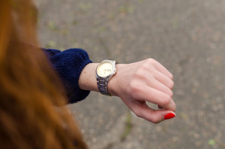 Close up of young woman looking at her hand watchの写真素材