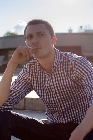 Young man smoking cigarette on the street