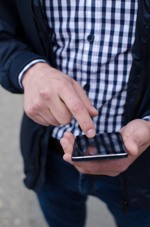 Young man using his phone on the streetの写真素材