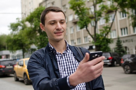 Young man making selfie with his phone on the street