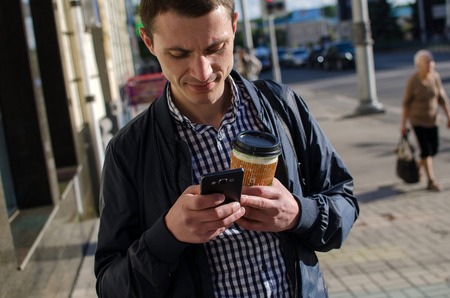 Young man using his phone on the street