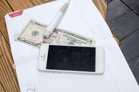 Top view of cellphone, money and the day plannerの写真素材