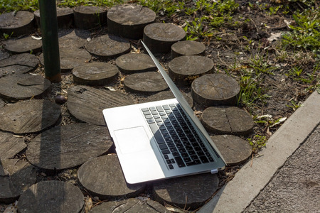 Laptop on the wooden ground outdoorsの写真素材