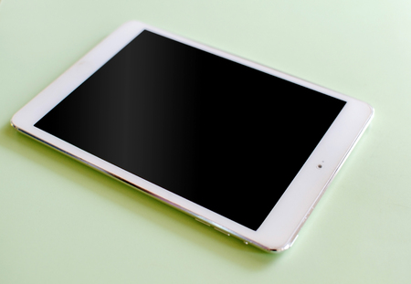 White tablet lying on the table in the caffeeの写真素材