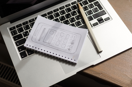 Silver laptop with sketchbook on the table